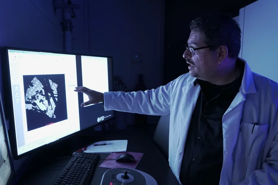 Gonen pointing at computer in lab